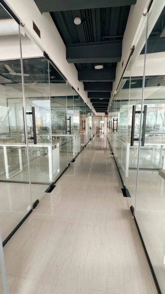 Corridor lined with glass-walled private cabins at Workinger, Dharampeth